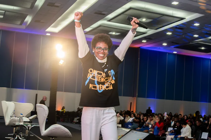 Zazá Sousa com braços levantados no palco do Favela Mais Rica